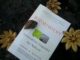 Foto do livro "Biomimicry" da pesquisadora Janine Benyus no chão em meio a flores e terra.